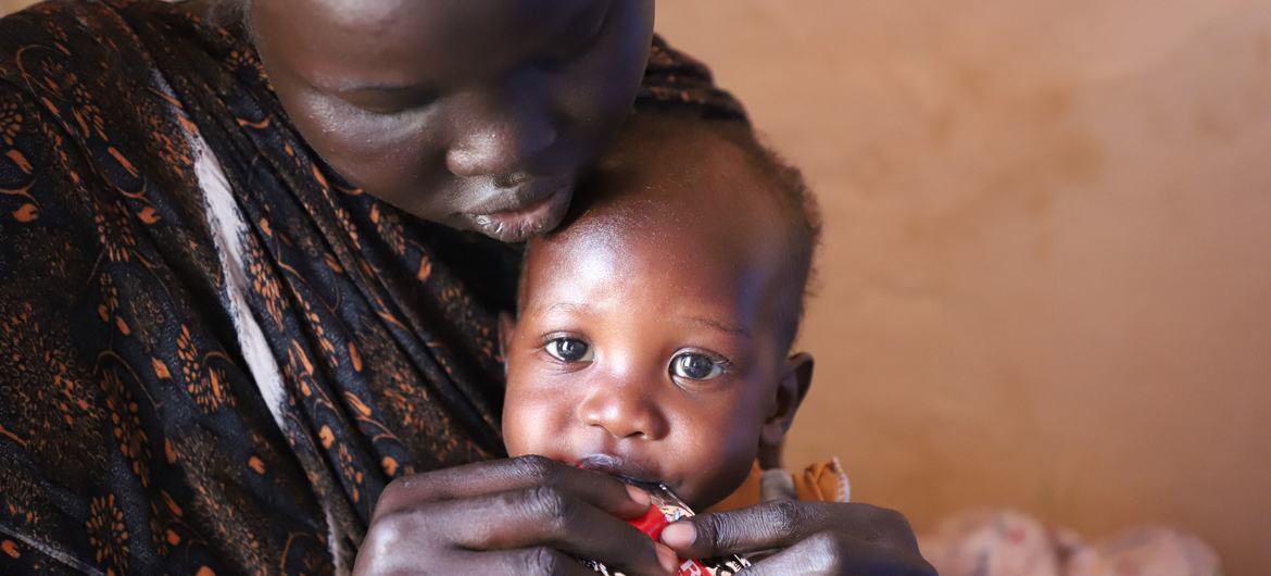 In Renk, in northern South Sudan, a mother feeds her child therapeutic food.

