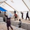 يقوم موظفو WFP بتحميل أكياس المساعدات الغذائية على الشاحنات داخل مستودع في مكتب بور الميداني في ولاية جونقلي، جنوب السودان.