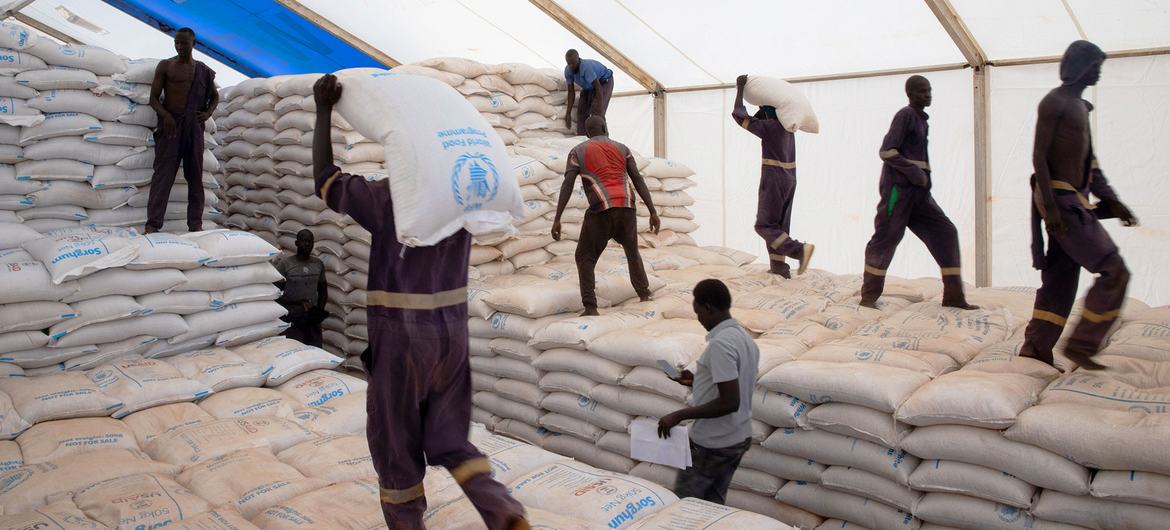 يقوم موظفو WFP بتحميل أكياس المساعدات الغذائية على الشاحنات داخل مستودع في مكتب بور الميداني في ولاية جونقلي، جنوب السودان.
