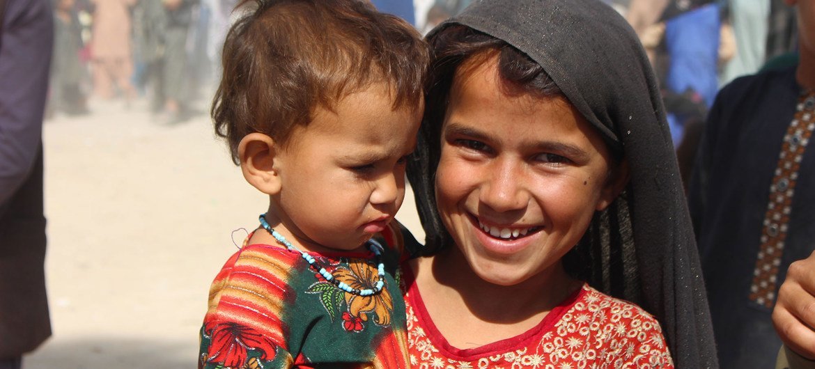 Una niña de siete años sostiene a su hermana menor en un campo de desplazados internos en Kandahar, al suroeste de Afganistán.