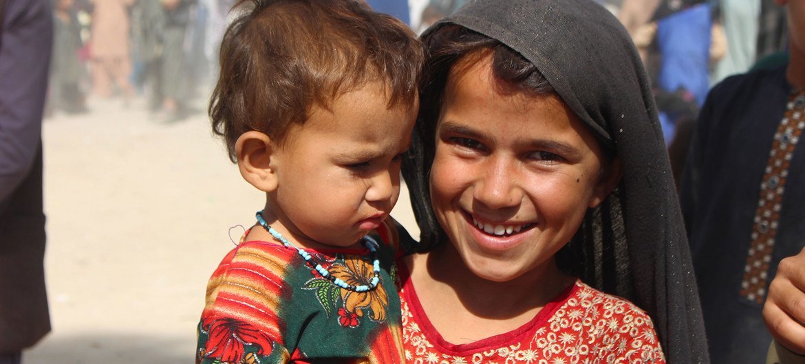 A seven-year-old girl holds her younger sister in an IDP camp in Kandahar, southwestern Afghanistan.