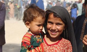 A seven-year-old girl holds her younger sister in an IDP camp in Kandahar, southwestern Afghanistan.
