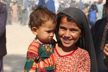 Menina de sete anos com sua irmã mais nova em um campo de deslocados internos em Kandahar, sudoeste do Afeganistão