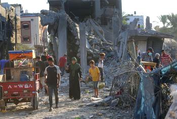 La gente camina entre los escombros de los edificios destruidos en Gaza.
