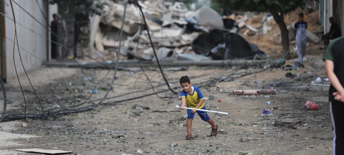 A young boy plays in the street amidst the wreckage of homes destroyed by airstrikes in Al Shati Refugee Camp in the Gaza Strip.