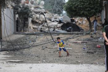 加沙地带沙蒂难民营，一名小男孩在被空袭摧毁的房屋废墟中玩耍。