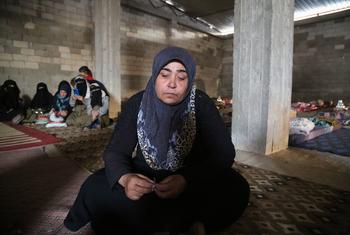 Una mujer sentada en un refugio para desplazados tras huir de su hogar en el norte de Siria.