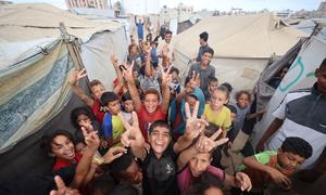 Children in Gaza celebrate the announcement of a ceasefire in October 2025.