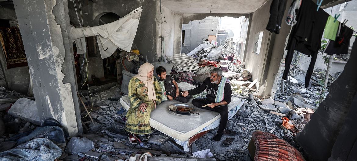 Uma família cozinha nos escombros de sua casa na Faixa de Gaza