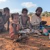 A woman and her grandchildren prepare manioc for dinner in Madagascar.