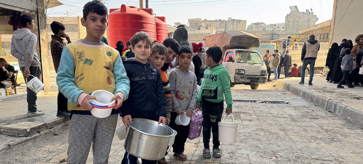 Children queue for hot food in Aleppo, Syria.