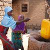 Des filles vont chercher de l'eau dans un puits devant leur maison à Dedougou, au Burkina Faso.
