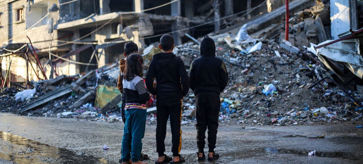 غزہ کے علاقے رفح میں بچے بمباری میں تباہ ہو جانے والے اپنے گھروں کے ملبے کے قریب کھڑے ہیں۔