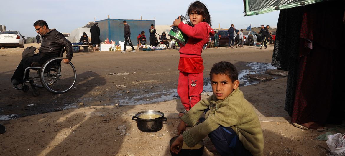 طفلان نازحان يبحثان عن الطعام بالقرب من الخيام التي يقيمان فيها مع ذويهما، في مدينة رفح جنوب قطاع غزة.