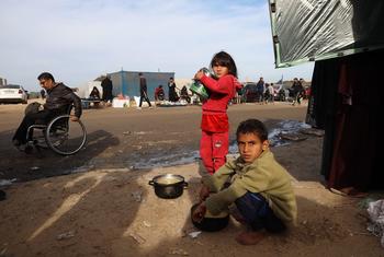 طفلان نازحان يبحثان عن الطعام بالقرب من الخيام التي يقيمان فيها مع أسرتيهما، في مدينة رفح جنوب قطاع غزة.