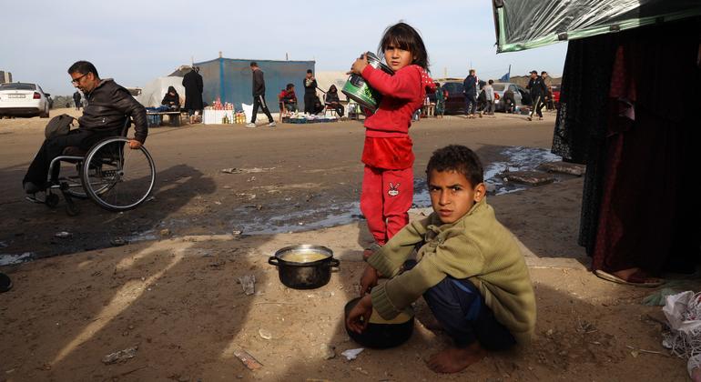 加沙地带南部拉法市，流离失所的儿童在他们和家人住的帐篷附近寻找食物。