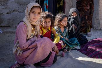 سيدة أفغانية (في الخلفية) مع بناتها. 