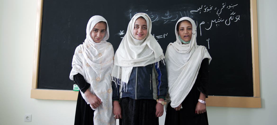 Tres alumnas de quinto grado posan frente a un aula recién construida en la escuela para niñas Soroubi en Afganistán.