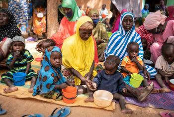 أم تطعم طفلها خلال جلسة توعية حول التغذية في النيجر.