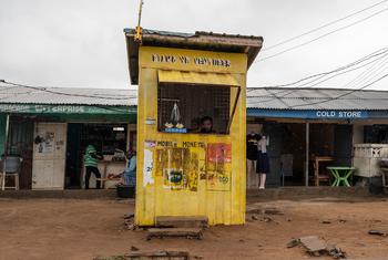 घाना के अकरा में एक महिला अपने मोबाइल मनी स्टैंड पर.