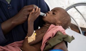 Mona, une enfant de trois ans gravement malnutrie, est nourrie à la seringue par un professionnel de santé à l'hôpital de Paris géré par MSF à Tawila, au Darfour du Nord, au Soudan, en février 2026.