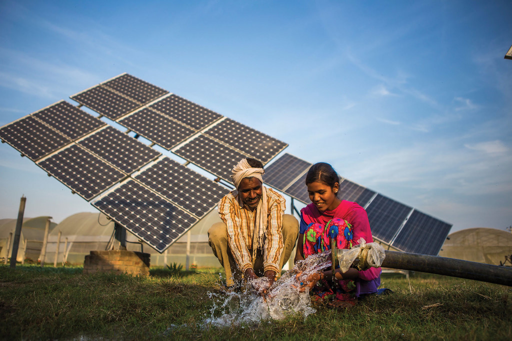 Sukhdev Vishwakarma y su hija Meenu, ambos trabajadores agrícolas, utilizan el agua facilitada por una bomba solar en las granjas de Gurinder Singh, un agricultor de 80 hectáreas en Jagadhri, India.