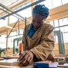 A student on the Youth Rising training project learns carpentry in a workshop.