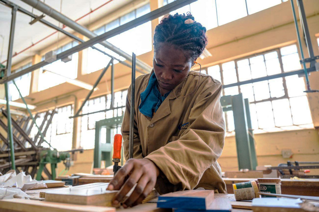 A student on the Youth Rising training project learns carpentry in a workshop.