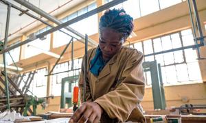 A student on the Youth Rising training project learns carpentry in a workshop.