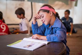 在约旦，一名年幼的叙利亚难民在联合国儿童基金会支持的中心学习。