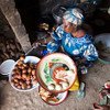 Une femme réfugiée centrafricaine vivant au Cameroun prépare de la nourriture pour ses clients.