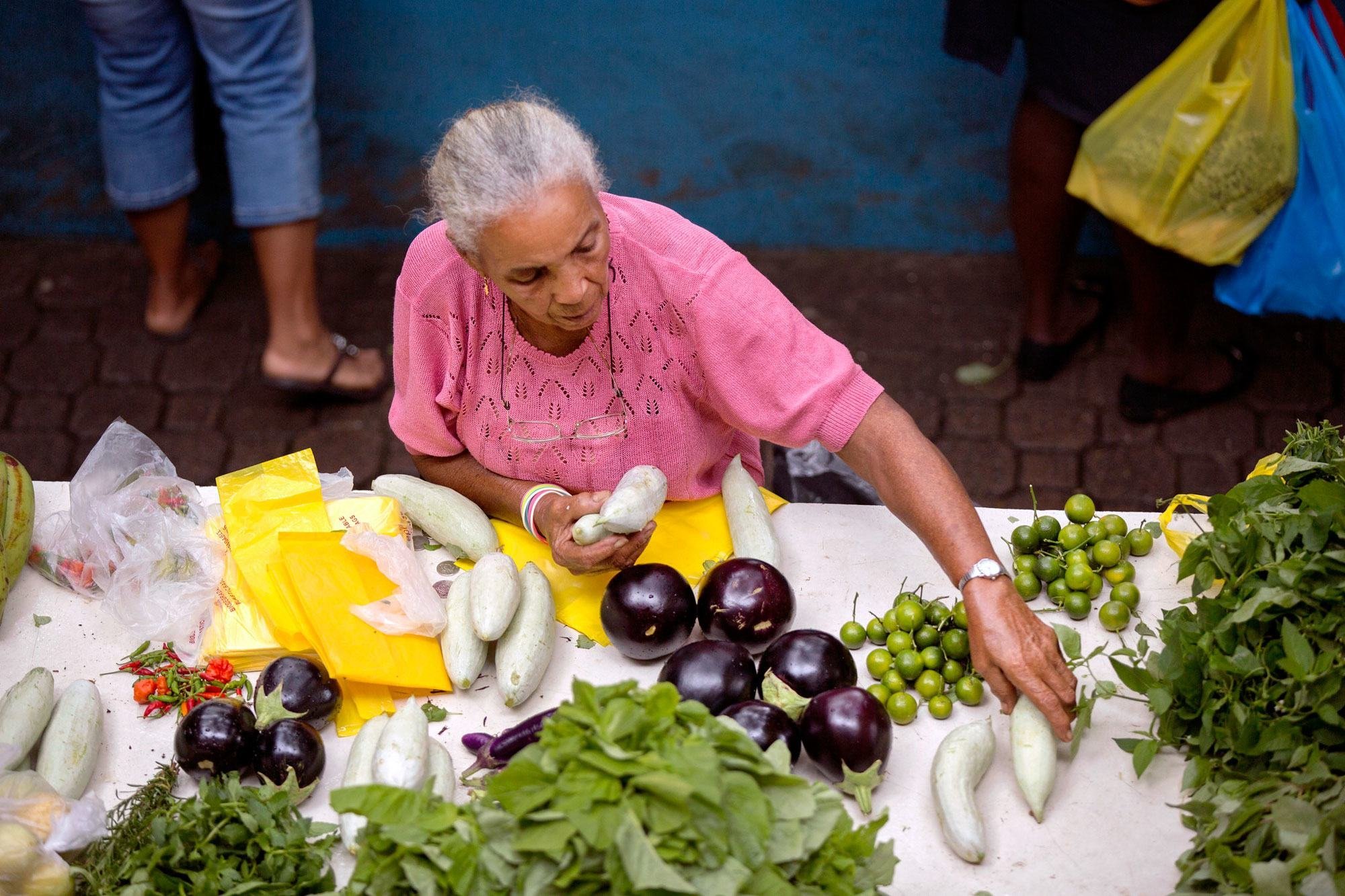 Une femme vend des légumes sur un marché aux Seychelles. La réalisation des objectifs de développement durable liés à l'autonomisation des femmes reste en deçà des cibles fixées pour 2030.