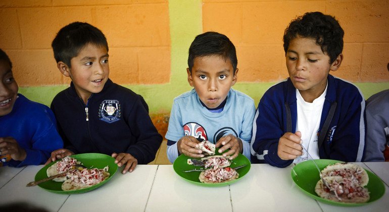 危地马拉的小学生在学校吃午餐。