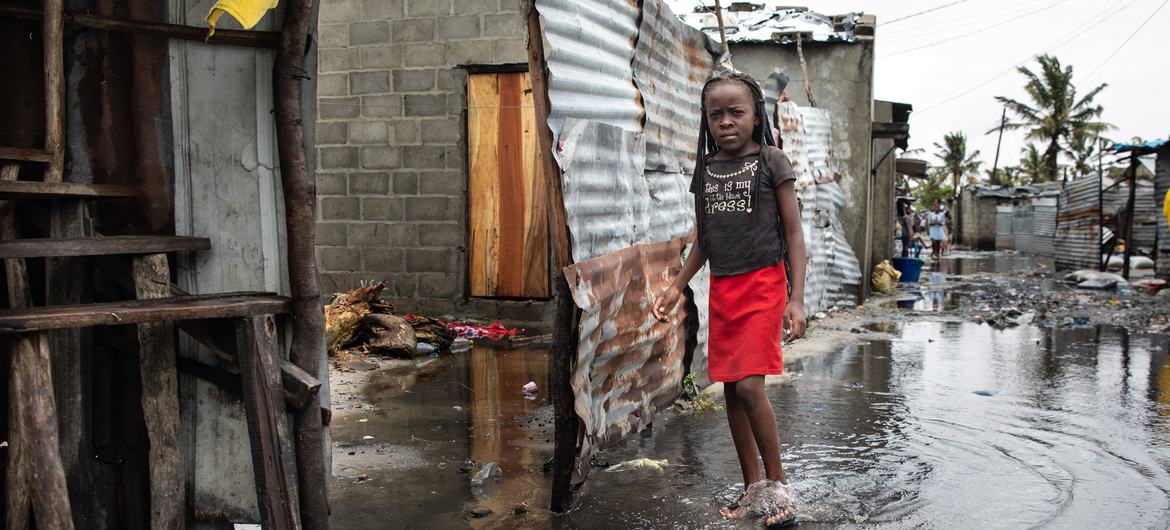 Seorang anak di Beira, Mozambik, berdiri di air yang naik setelah kehancuran Topan Idai pada 2019. 