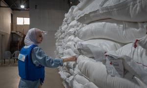 A UN worker checks food supplies in a warehouse in Nuseirat, Gaza.