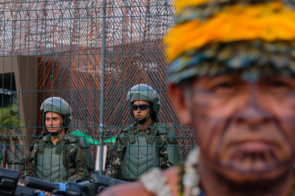 قوات الأمن تحرس مكان انعقاد مؤتمر الأمم المتحدة للمناخ في بيليم، البرازيل، أثناء احتجاج شعب موندوروكو الأصلي.
