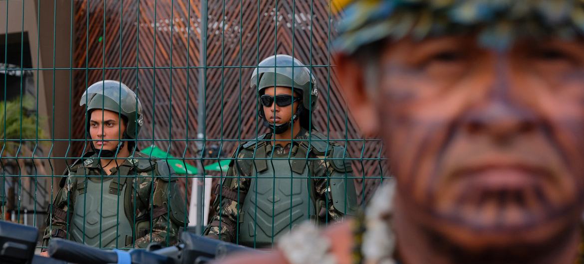 Security officers guard the UN Climate Conference venue as the Munduruku Indigenous People protest.