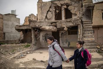Dans la vieille ville de Mossoul, en Iraq, Noor, 15 ans (à gauche) et sa cousine Rahaf marchent ensemble jusqu'à l'école.