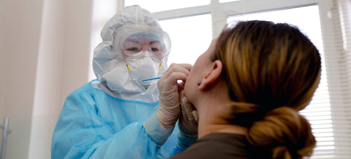 एक महिला का कोविड-19 संक्रमण जाँचने के लिए परीक्षण किया जा रहा है.