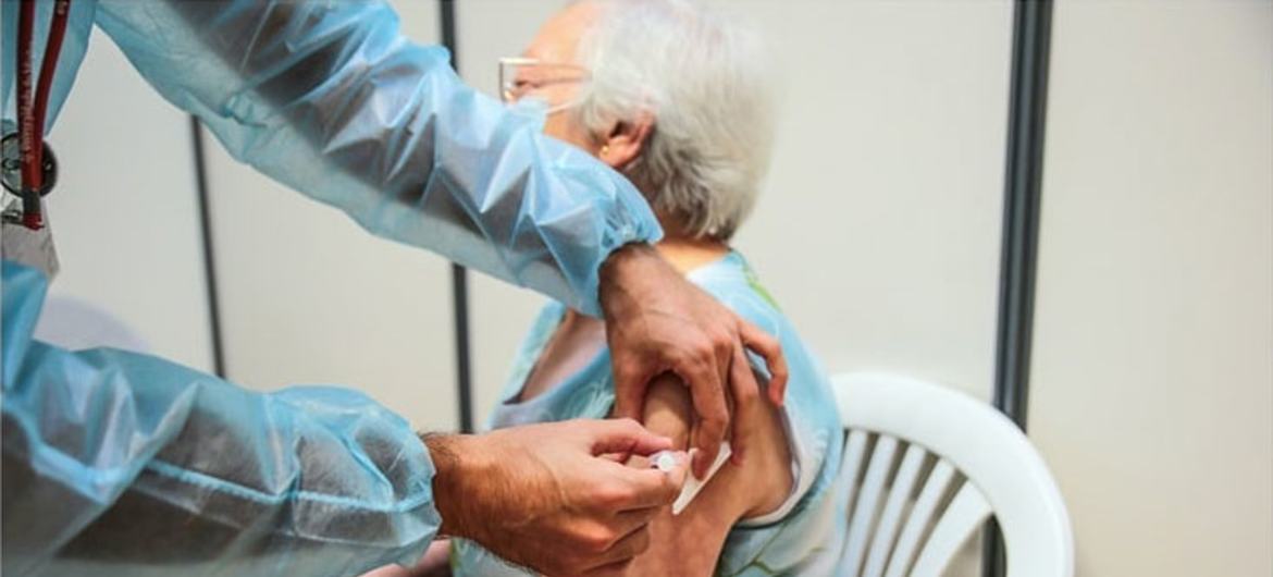 An elderly woman receives her third COVID-19 booster shot at a  vaccination centre in Lisbon, Portgual.  