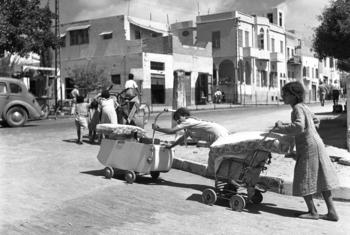 阿拉伯家庭赤脚用婴儿车和手推车推着财务，离开沿海城镇雅法，雅法后来成为了以色列国大特拉维夫地区的一部分。