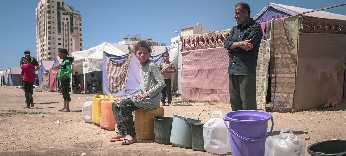 Des habitants font la queue pour remplir leurs bidons d'eau dans la ville de Gaza.