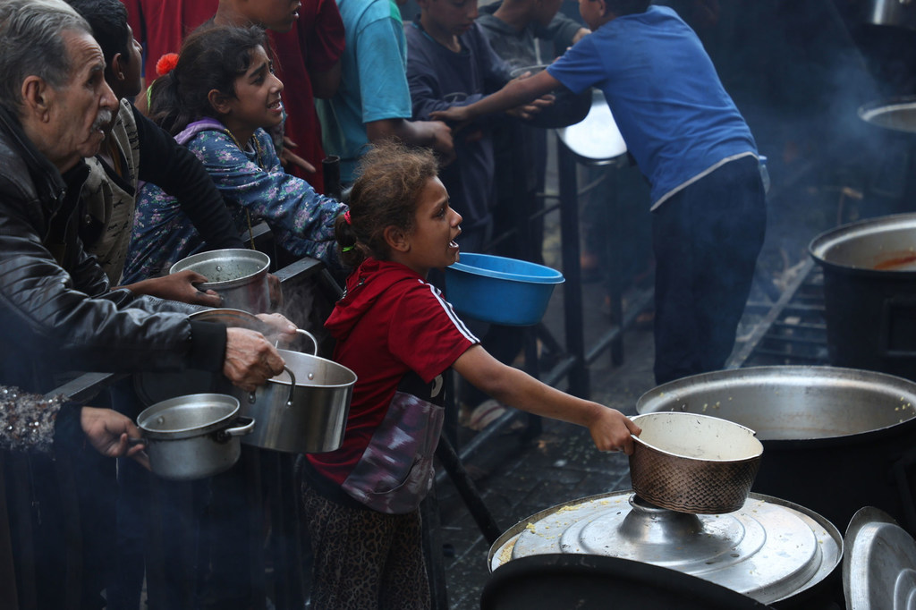 People plea for food at a communal kitchen in Gaza.