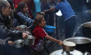 People plea for food at a communal kitchen in Gaza.