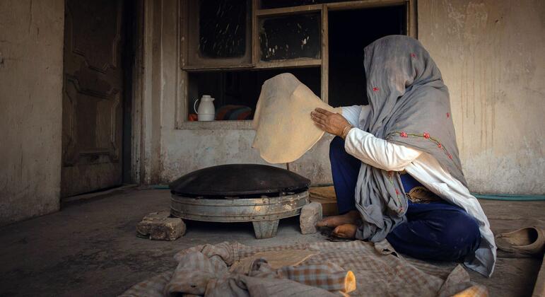 Une femme en Afghanistan pétrit de la pâte dans une boulangerie.