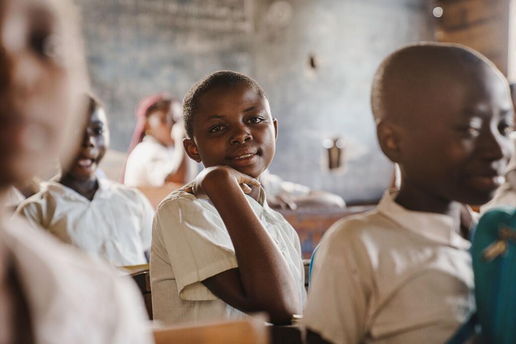 Mapendo, a 12-year-old student, smiles while sitting in a classroom at Minova remedial school in South Kivu province, DR Congo.