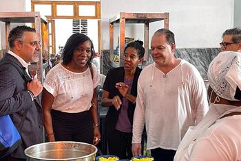 Edem Wosornu, OCHA's Director of Operations and Advocacy, speaks with staff in a kitchen during a food distribution event.