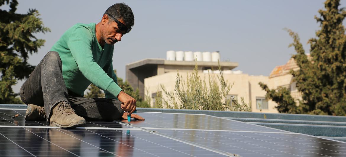 A worker installs a solar array in Jordan. 