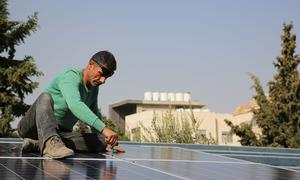 A worker installs a solar array in Jordan. 