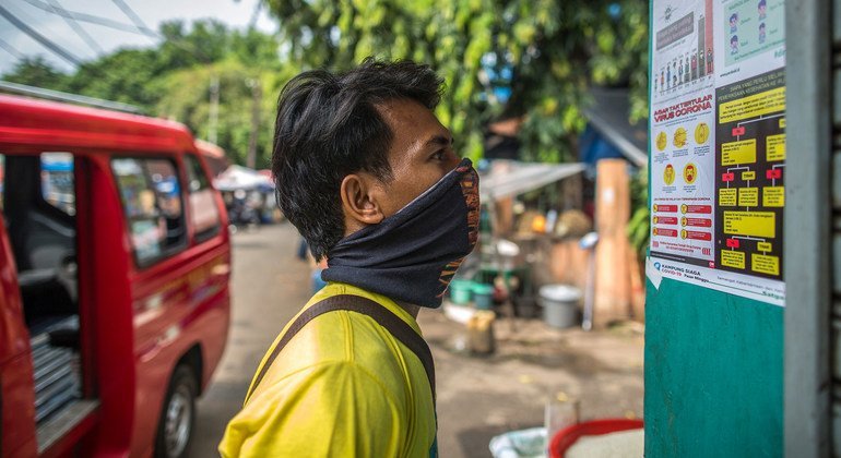 Un homme lit des informations sur la prévention du COVID-19 à Jakarta, en Indonésie.